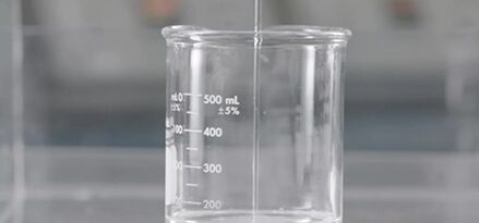 A beaker with liquid being poured into it.