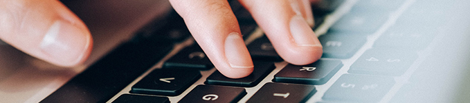 Laptop keyboard with man typing