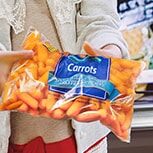 Little Girl with carrots in food packaging