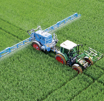 Tractor spraying pesticides on field