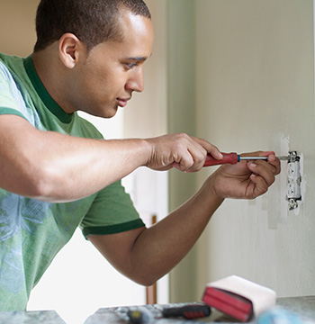Man screwing in screw with tools.