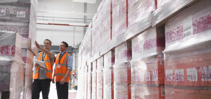 Two men in warehouse looking at PPS film