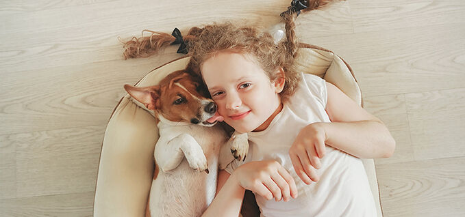 Girl and pet dog lying on the resilient floor
