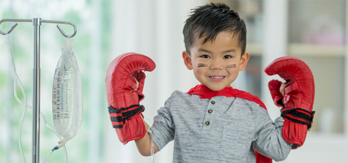 A boy wearing boxing gloves determined to fight with disease